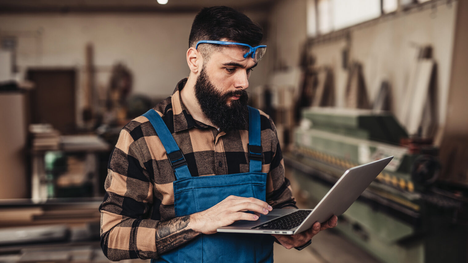 Mann in Werkstatt mit Laptop