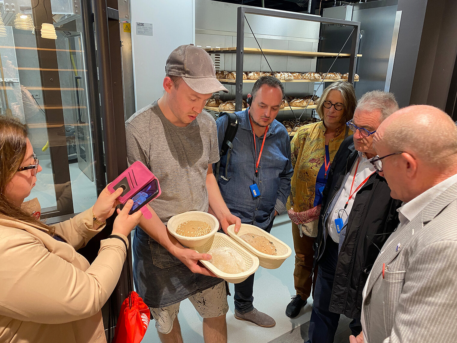 Der trinationale Austausch zwischen Polen, Frankreich und Deutschland. Junger Bäcker zeigt 3 verschiedene Brote vor Backen