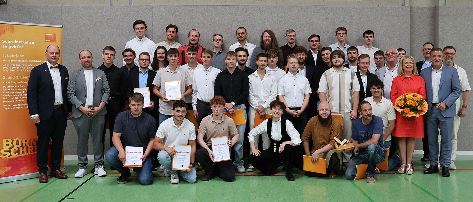 Freisprechung Schreinerinnung Mainfranken Gruppenbild mit ca. 40 stehenden Personen in mehreren Reihen - Ausbildungsabsolventen umrahmt von Ehrengästen
