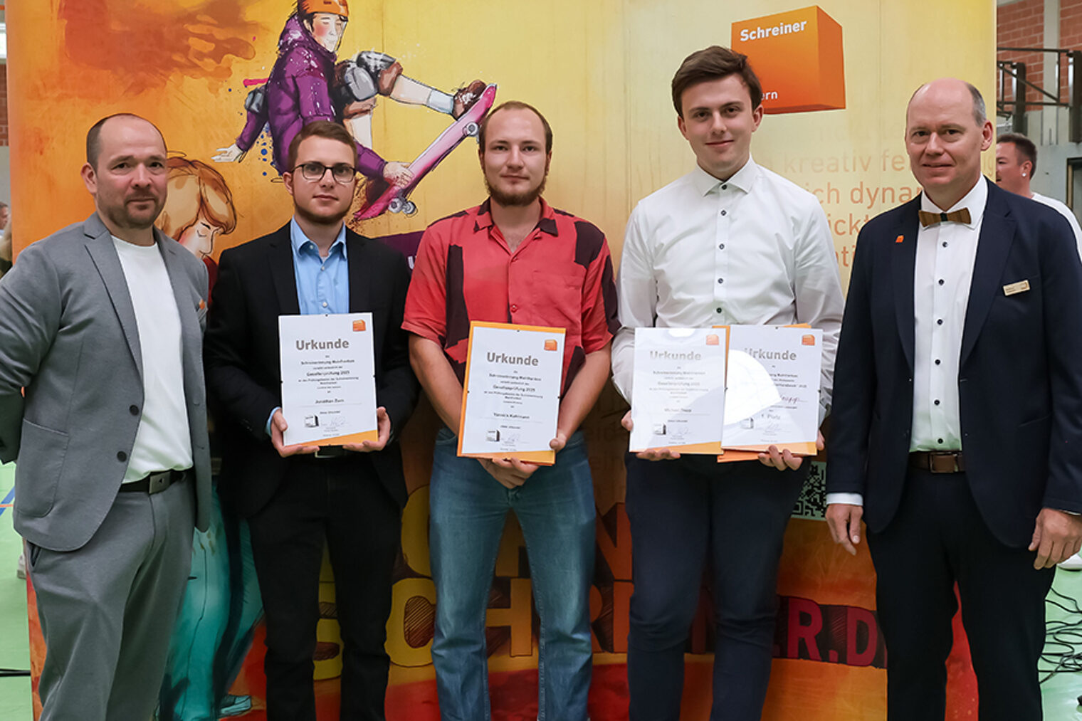 Gruppenbild der Prüfungsbesten mit Urkunden, umrahmt von Obermeister und stv. Obermeister der Schreinerinnung Mainfranken