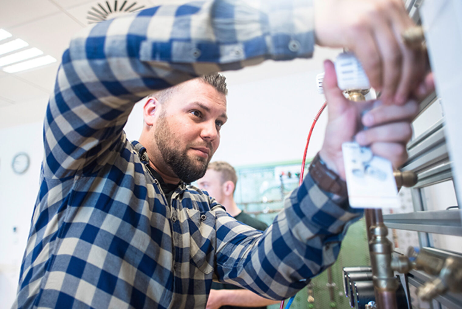 Heizungsanlage-Service im SHK-Kundendiensttechniker Kurs trainieren Weiterbildung SHK-Kundendiensttechniker/in in Aschaffenburg - Teilnehmer arbeitet an einer Heizungsanlage