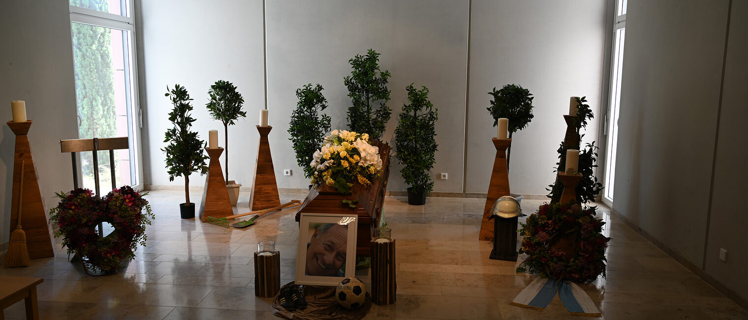 Trauerraum mit einem aufgebahrten Sarg und Kerzen