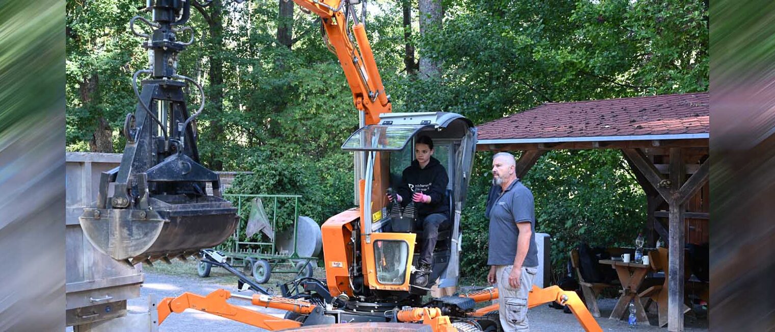 Auszubildende auf Bagger, Dozent leitet an