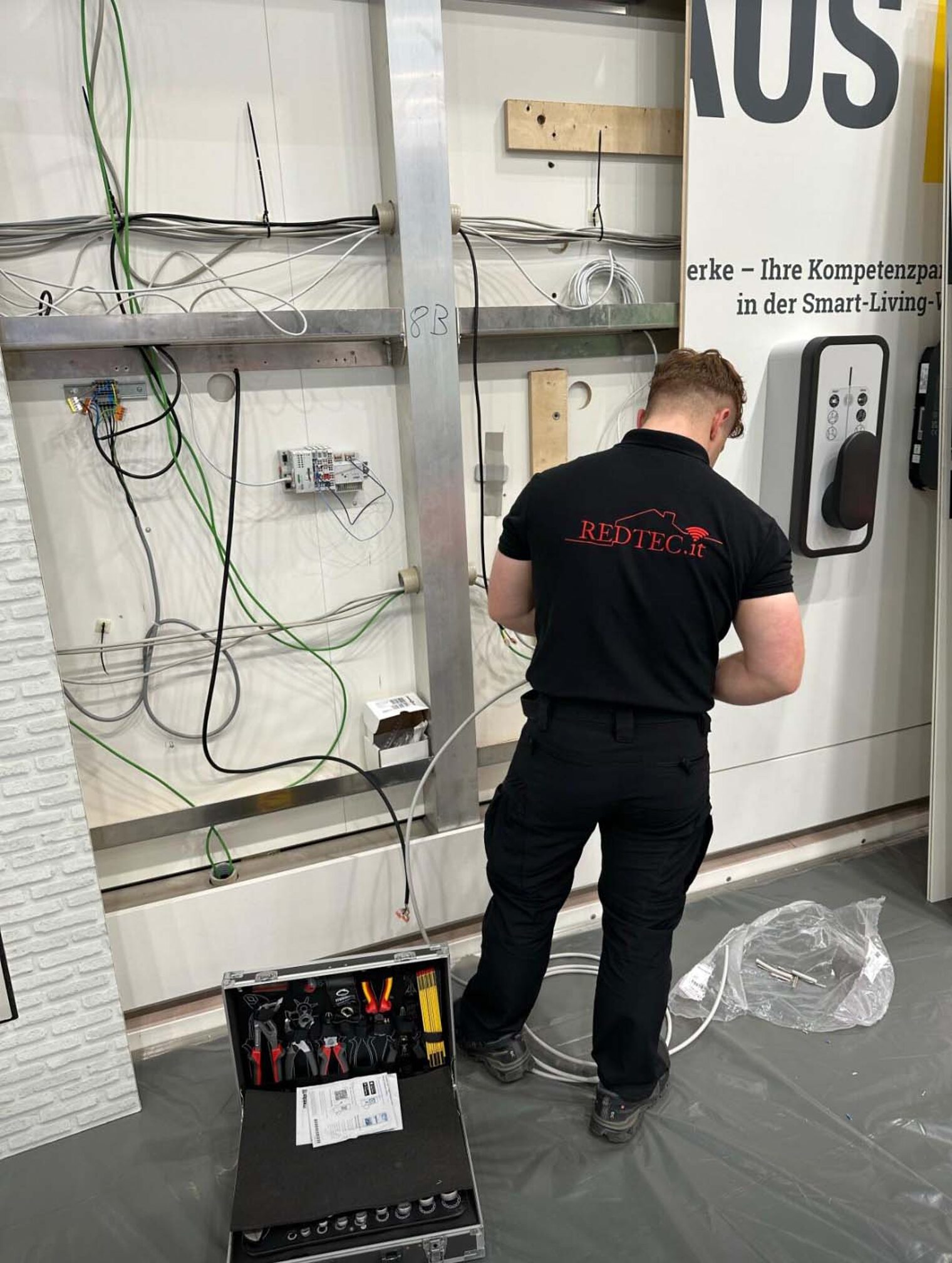 Elektroniker Gebäudesystemintegration steht vor einer Wand