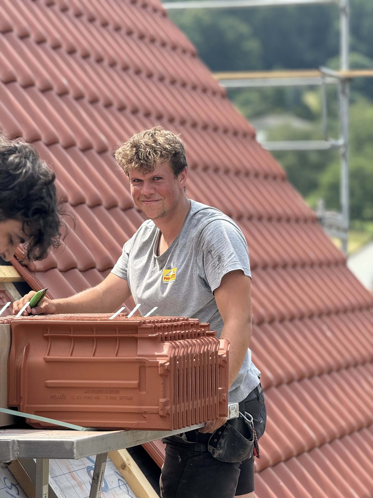 Dachdecker steht auf einem Haus