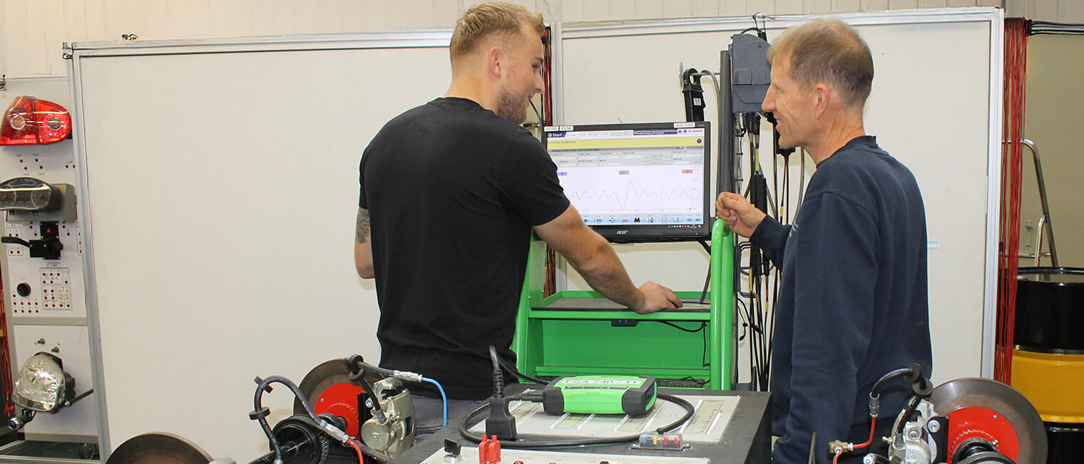 Ausbilder im Gespräch mit Azubi zur ABS Kontrolle in Kfz-Technik-ÜLU Freiberuflicher Kfz-Meister/in gesucht für ÜLU in Aschaffenburg – praxisnah im Werkstattalltag