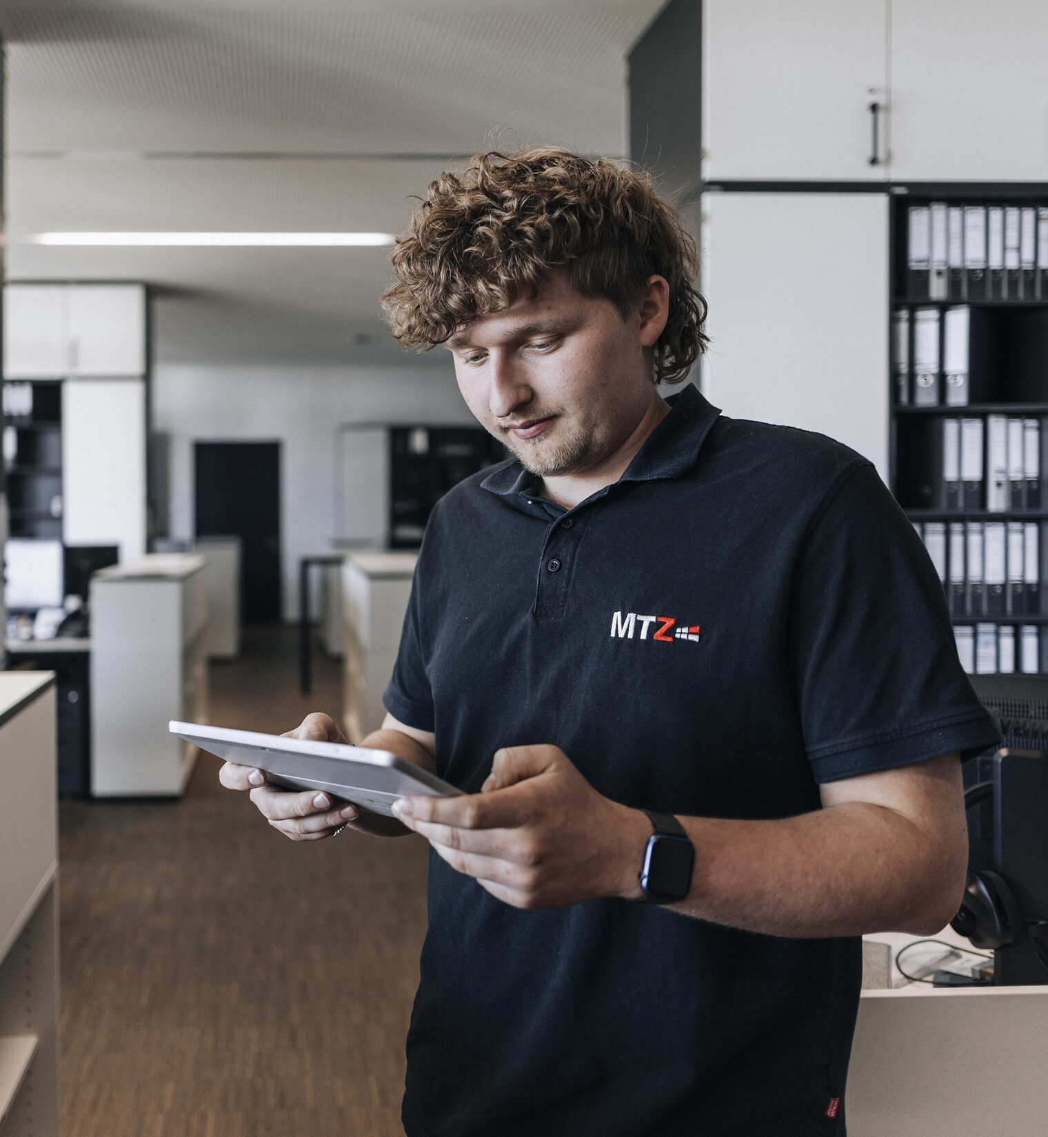 Maximilian Baier mit Tablet in der Hand im Büro