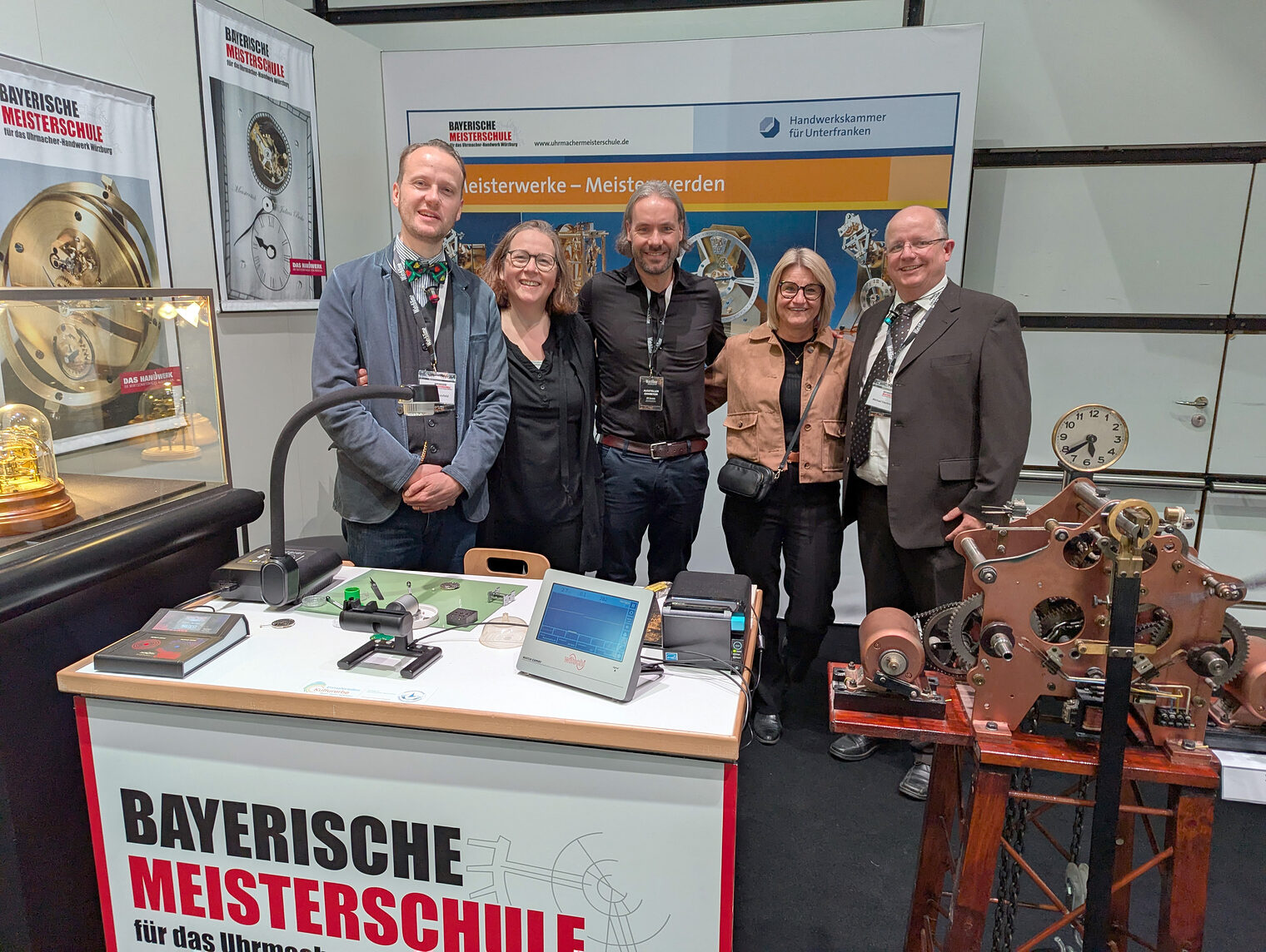 Gruppenfoto am Stand der Bayerischen Uhrmachermeisterschule auf der WatchTime 2025 in Düsseldorf