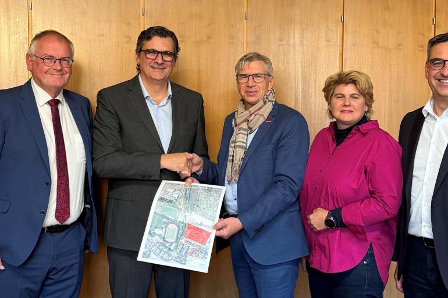 Gruppenfoto mit fünf Personen und Handschlag