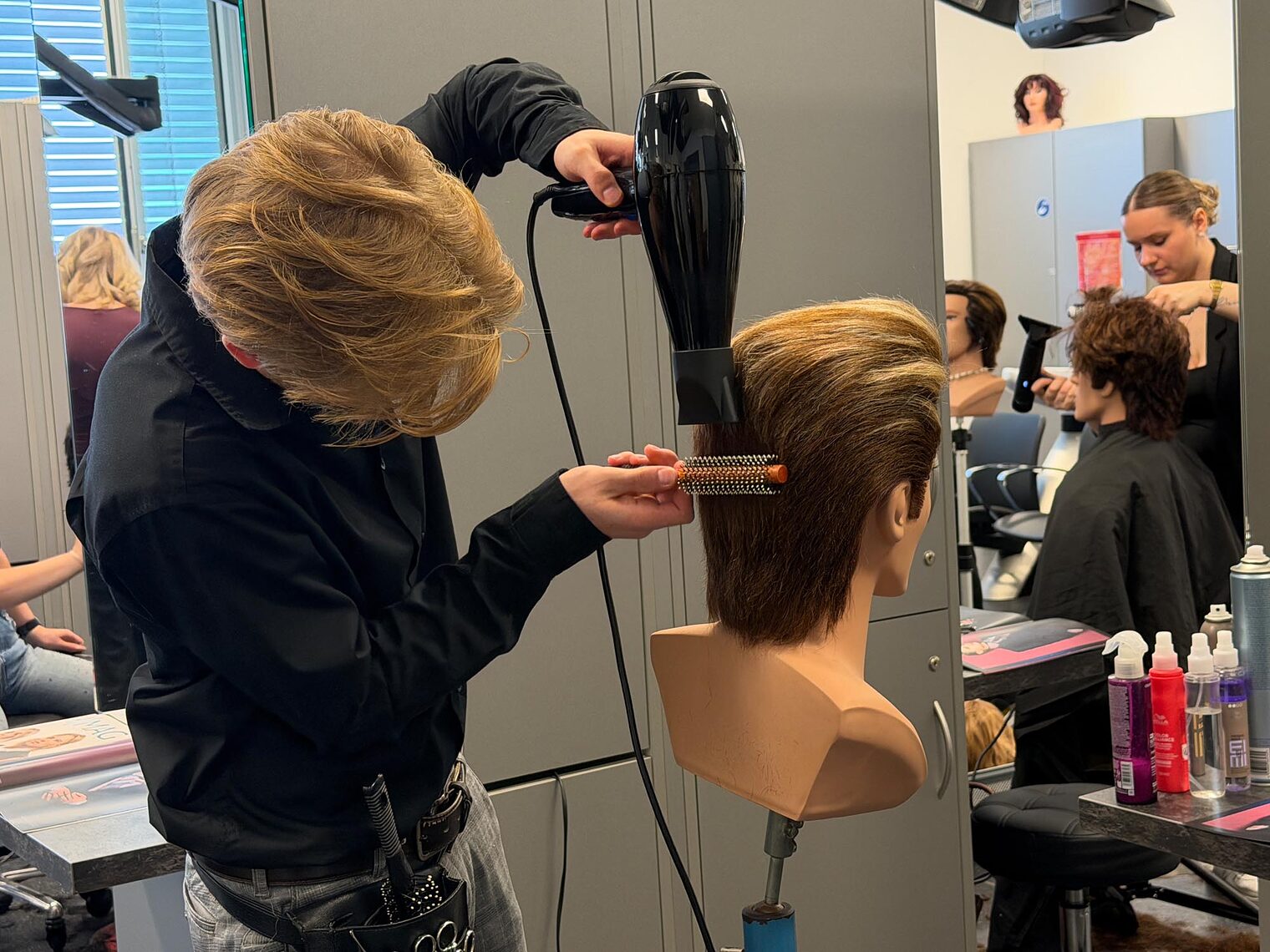 Friseur föhnt an Übungskopf