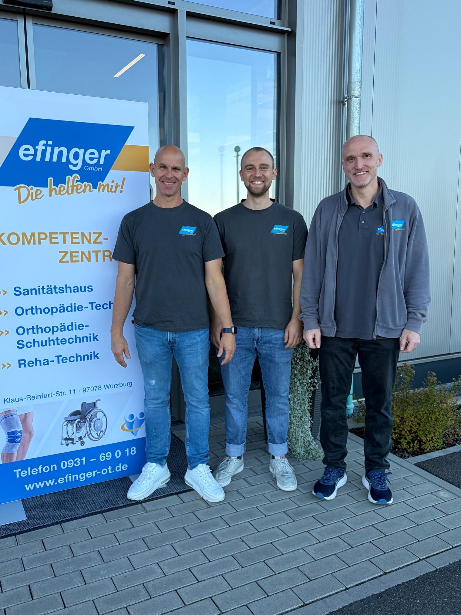 Gruppenfoto drei Personen vor Firma