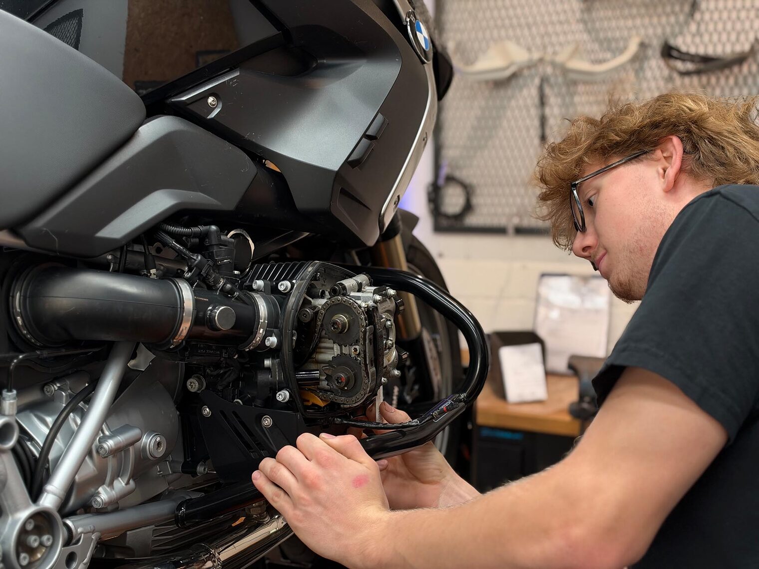 Zweiradmechatroniker schraubt Motorrad
